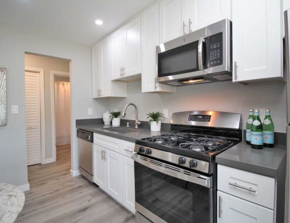 a kitchen with stainless steel appliances and white cabinets