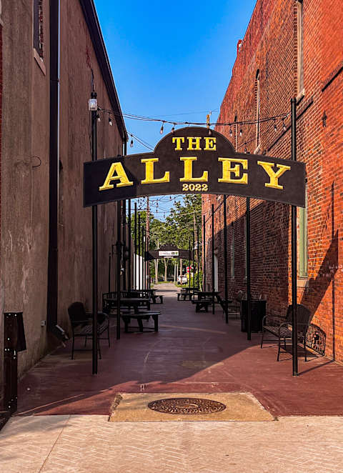 The Alley is a place with brick walls and tables outside.