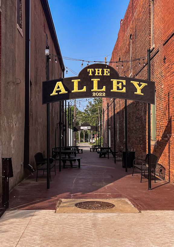 The Alley is a place with brick walls and tables outside.
