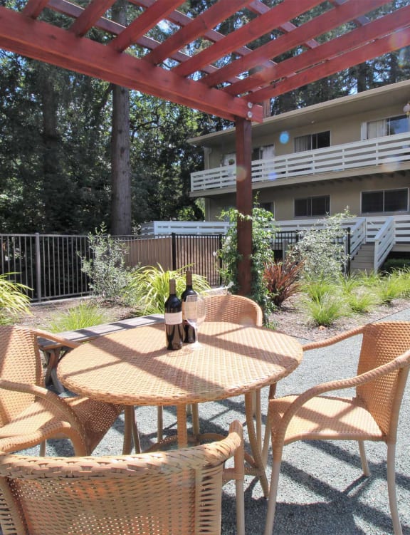 a patio with a table and chairs in front of a building