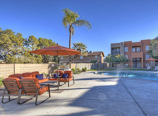 a swimming pool with chairs and umbrellas at the resort