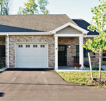 A house with a white garage door and a black gate.