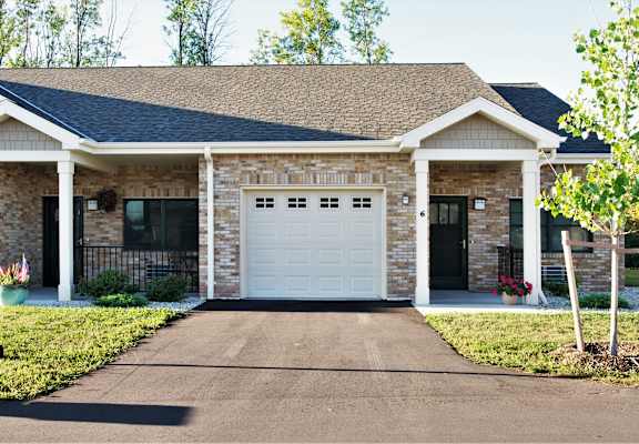 A house with a white garage door and a black gate.