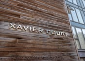 Thumbnail 1 of 5 - the front of a wood building with the word xavier court on it