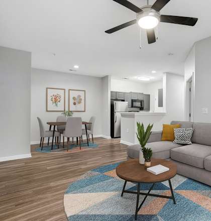 A living room with a grey couch, a coffee table, and a ceiling fan.