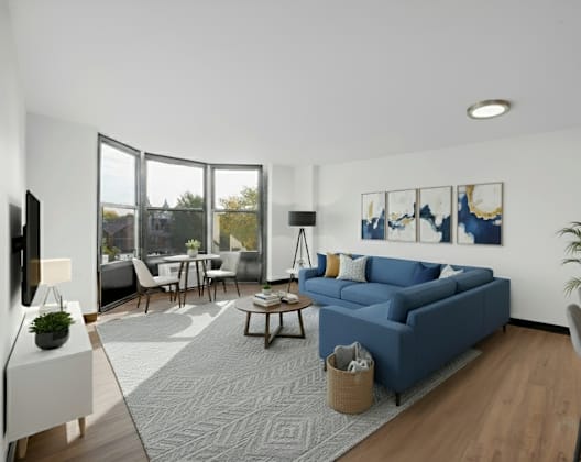 A modern living room with a blue sofa and a grey rug at Fullerton Court Apartments, Chicago