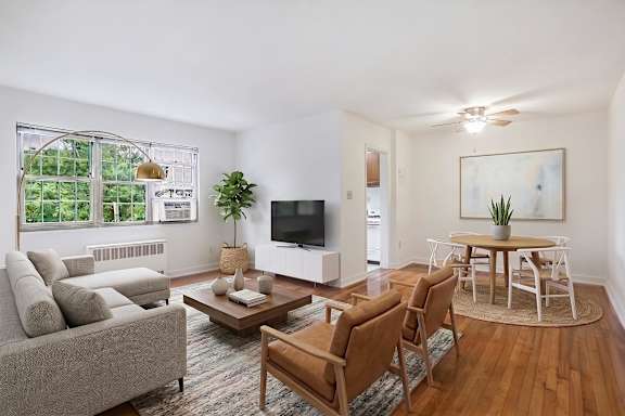 A living room with a grey couch, a wooden coffee table, and a television.