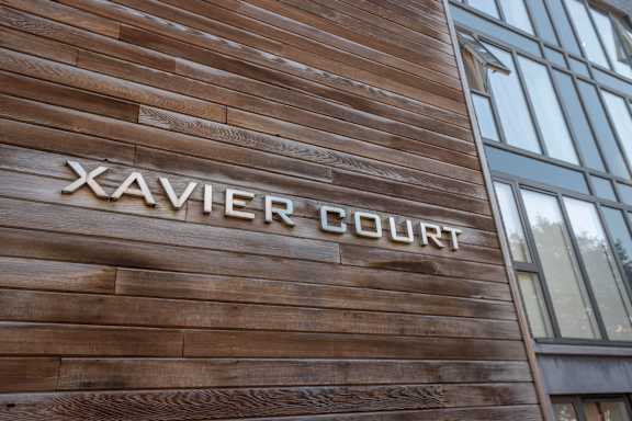 the front of a wood building with the word xavier court on it