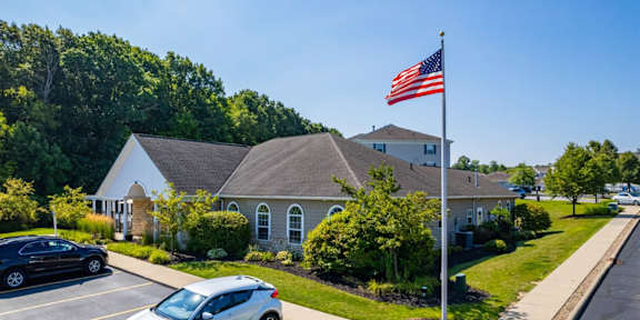 a house with an flag on a pole in a parking lot