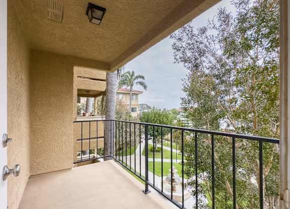 the balcony has a view of the backyard and the trees at Huntington Terrace North Senior, California