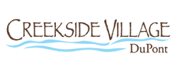 A black and white image of a mountain range with a river in the foreground and the words "Creekside Village Dupont" above it.