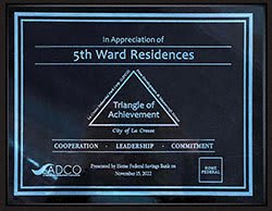 a plaque with a triangle of achievement with the words 5th ward residences