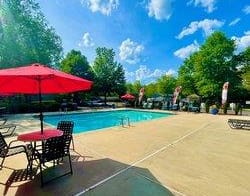 a swimming pool with tables and umbrellas at Hidden Creek, Morrow, GA 30260