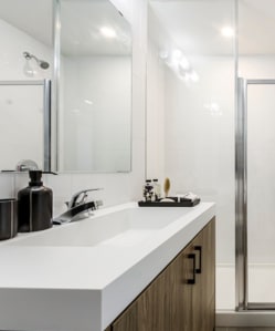 a white bathroom sink with a mirror and a shower
