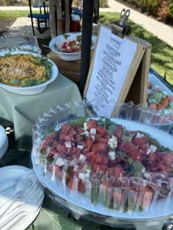 A buffet table with a variety of foods including a large platter of cubed meat.