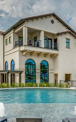 A large house with a pool in front.