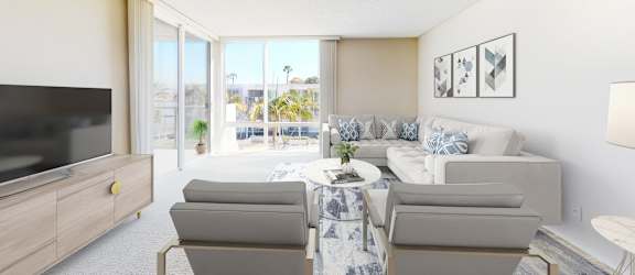 A living room with a grey couch, a coffee table, and a flat screen TV.