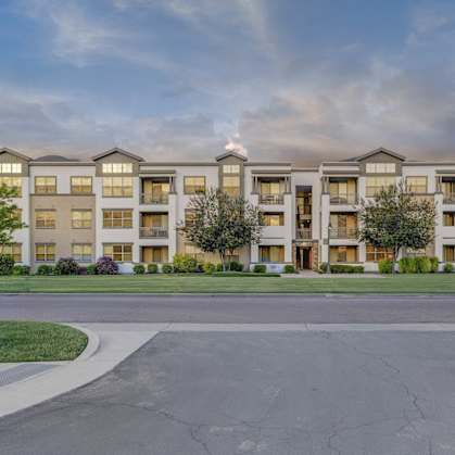 A large apartment complex with a grassy area in front.