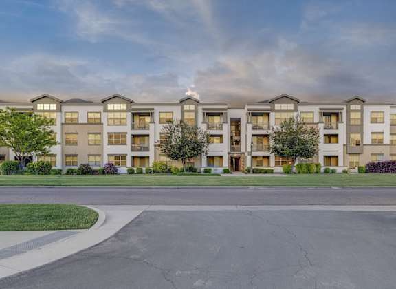 A large apartment complex with a grassy area in front.