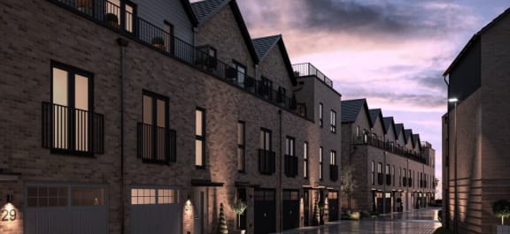 a rendering of a city street with brick buildings at dusk
