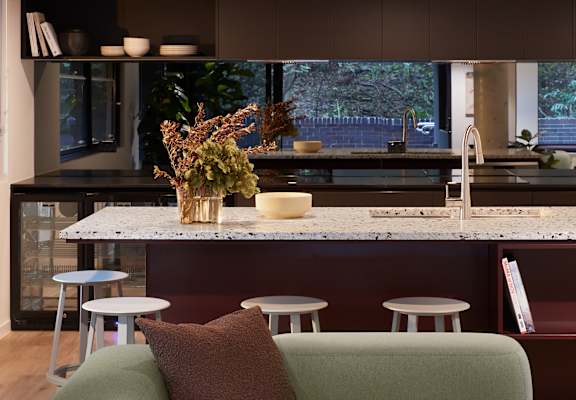 a kitchen with a marble counter top and a bunch of stools