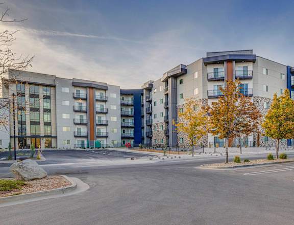 an empty parking lot in front of an apartment building