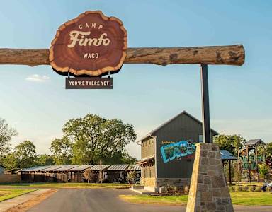 A wooden sign that says "Cana Furno Waco" is in front of a building.
