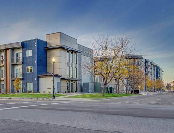 A modern apartment building with a parking lot in front.