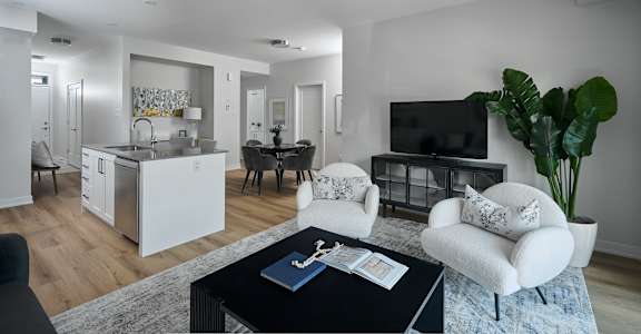 a living room with white furniture and a black coffee table