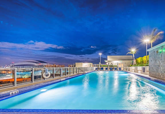 a swimming pool at night with a blue sky above it