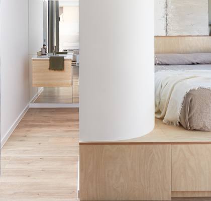 two views of a bedroom with a bed and a column