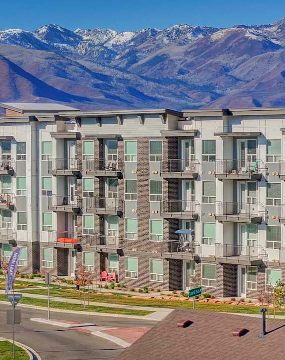 A large apartment complex with a mountain in the background.