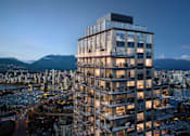 Thumbnail 7 of 8 - A tall, modern building with many windows is lit up at night.
