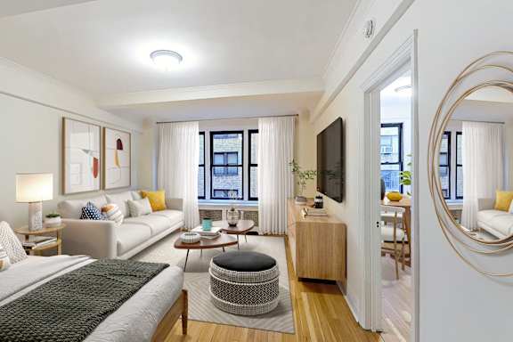 A bedroom with a large bed and a flat screen TV.at Sutton Collection, New York, NY