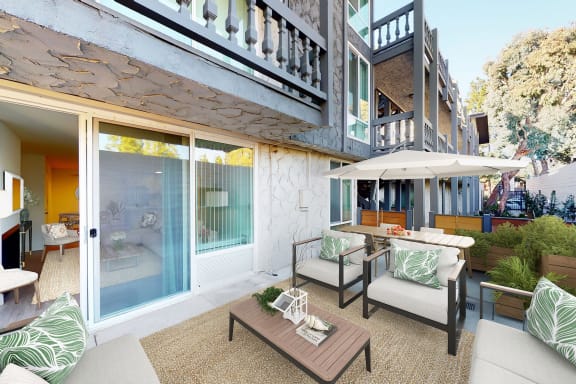 a patio with furniture and a table with a umbrella at The Meadows Apartments, Culver City , CA 90230