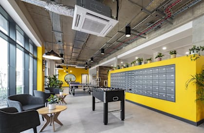 a game room with a foosball table and a yellow wall