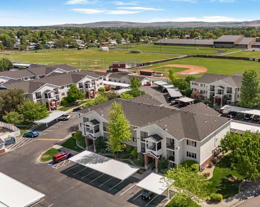 A large building with a baseball field in front of it.