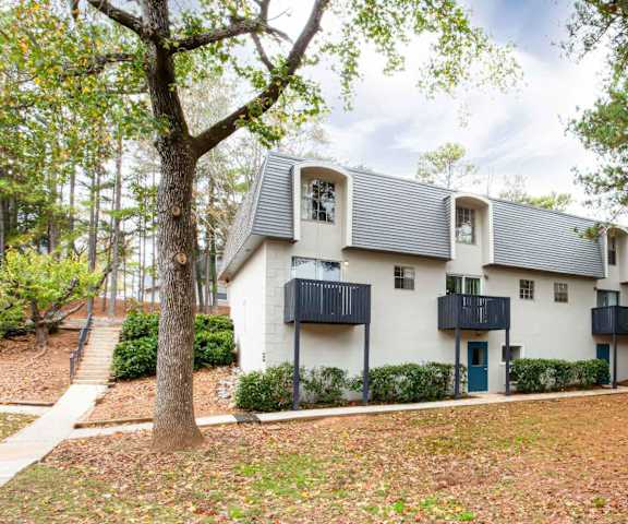 a white house with trees and a sidewalk at Elea Apartments in Marietta, GA
