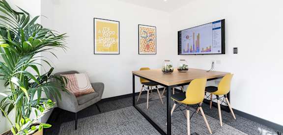 a dining area with a table and chairs and a television