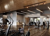 Thumbnail 6 of 8 - A gym with treadmills, weights, and exercise machines.