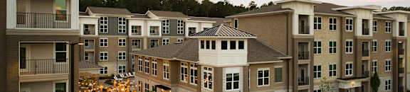 Apartment complex with a parking lot at Pointe at Lake Crabtree Apartments, Morrisville