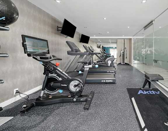 A modern gym with treadmills and exercise bikes.