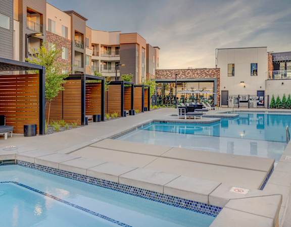 A swimming pool is surrounded by apartment buildings.