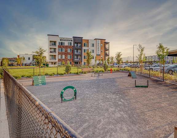 A playground with a slide and a basketball court in front of apartment buildings.