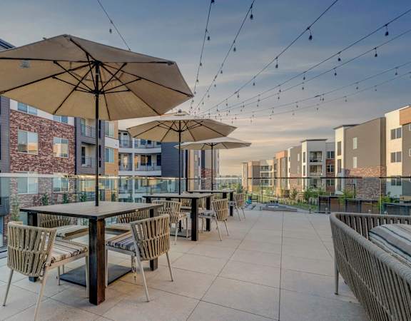 A patio with a table and chairs is surrounded by buildings.