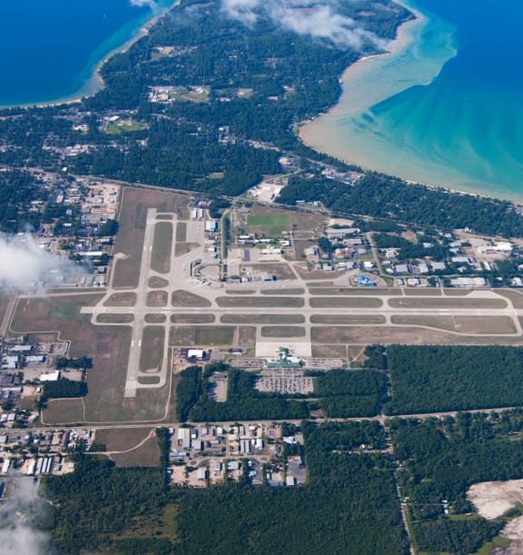 an aerial view of the airport with the ocean in the background