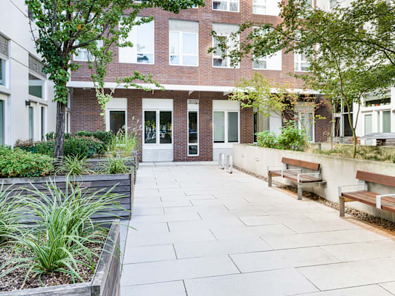 A courtyard with benches and a building in the background.