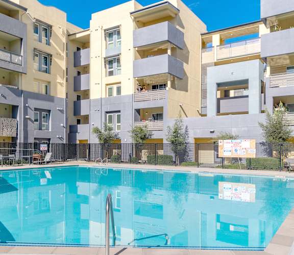 a swimming pool in front of an apartment building