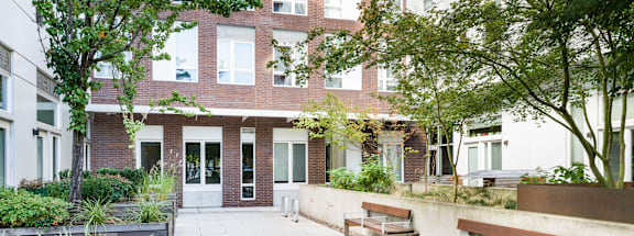 A courtyard with benches and a building in the background.