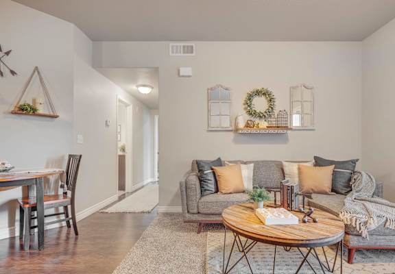 a living room with grey couches and a wooden coffee table